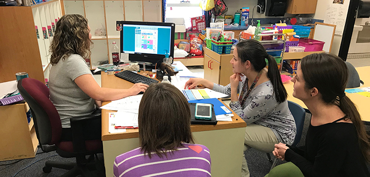 Teachers around a computer