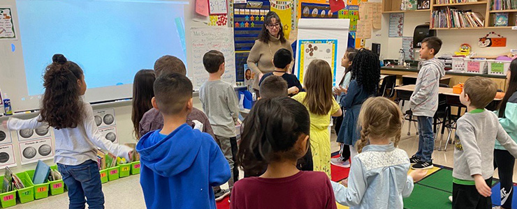 Teacher in classroom with boys and girls